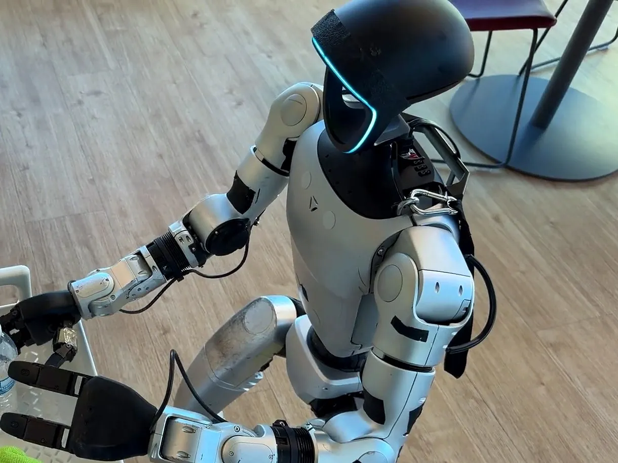 A Unitree G1 humanoid placing a bottle into a basket