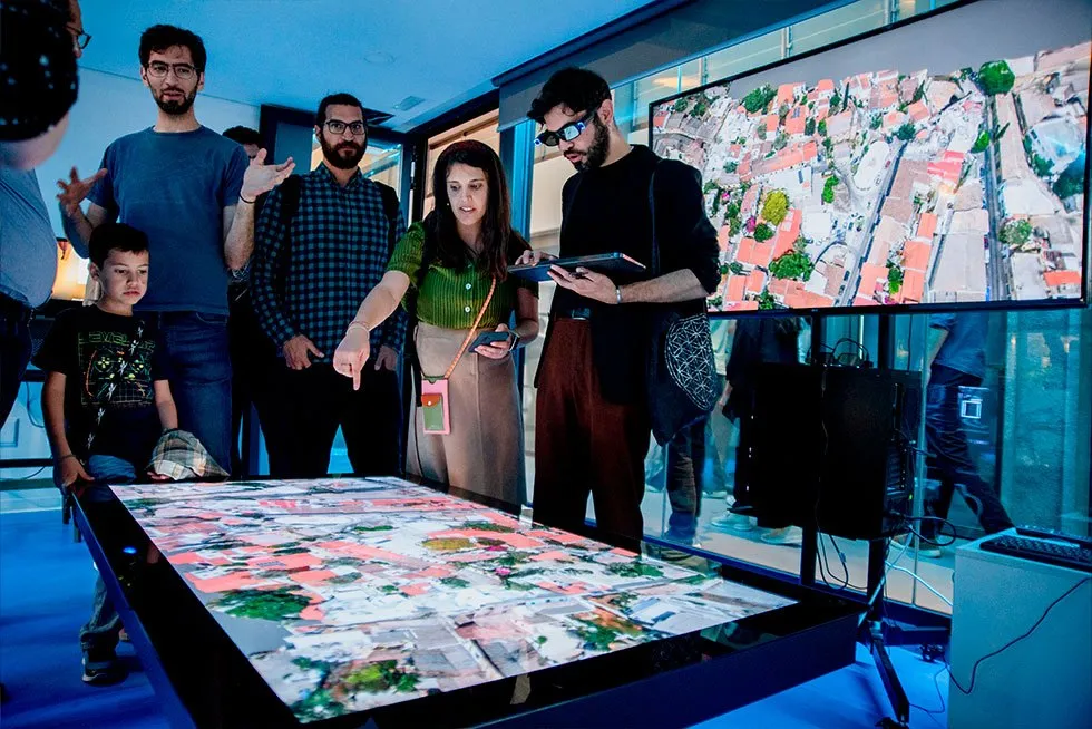 A group gathered around the ILLUMETRY EOS hologram table
